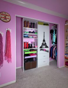 White shelves and wardrobe cabinet in Girl's reach in closet
