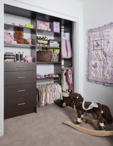Custom kids closet with brown built in shelves.