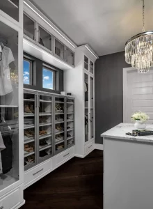 Walk in closet featuring a cabinet of drawers and a set of shelves for shoes