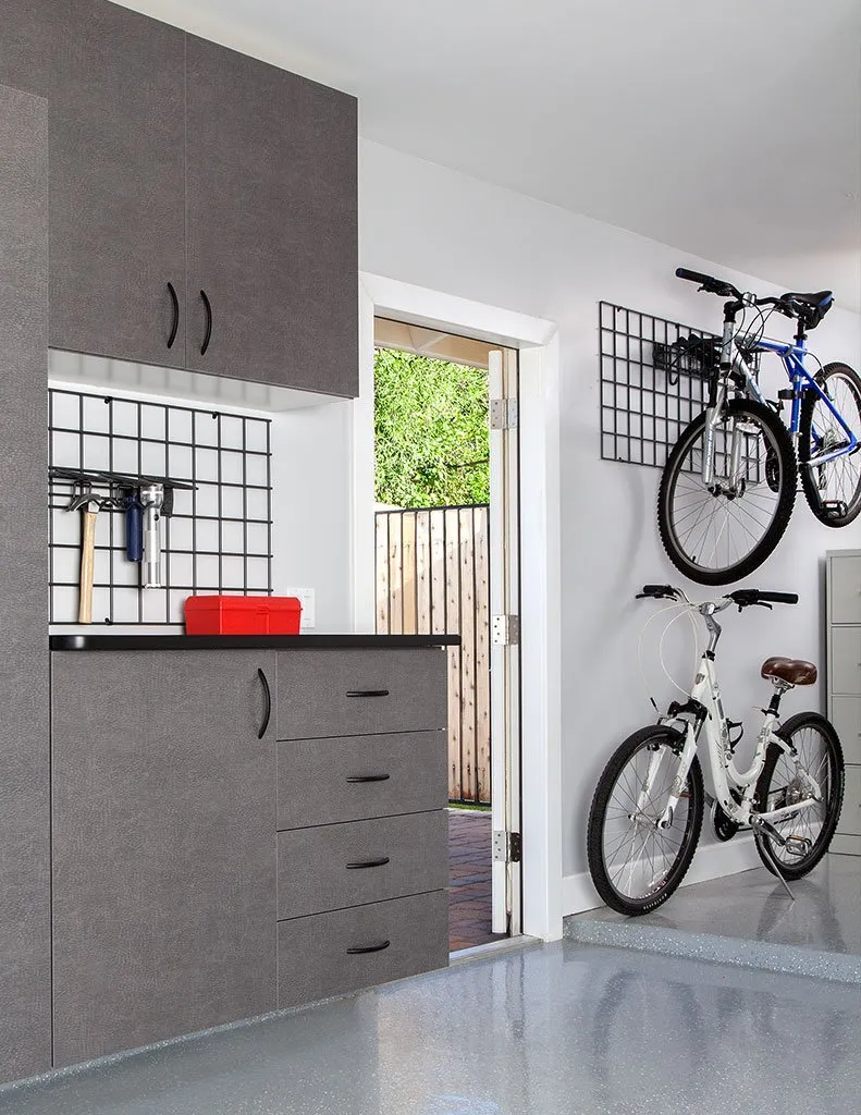 Custom garage storage solution including cabinets and 2 bikes hanging on the wall.