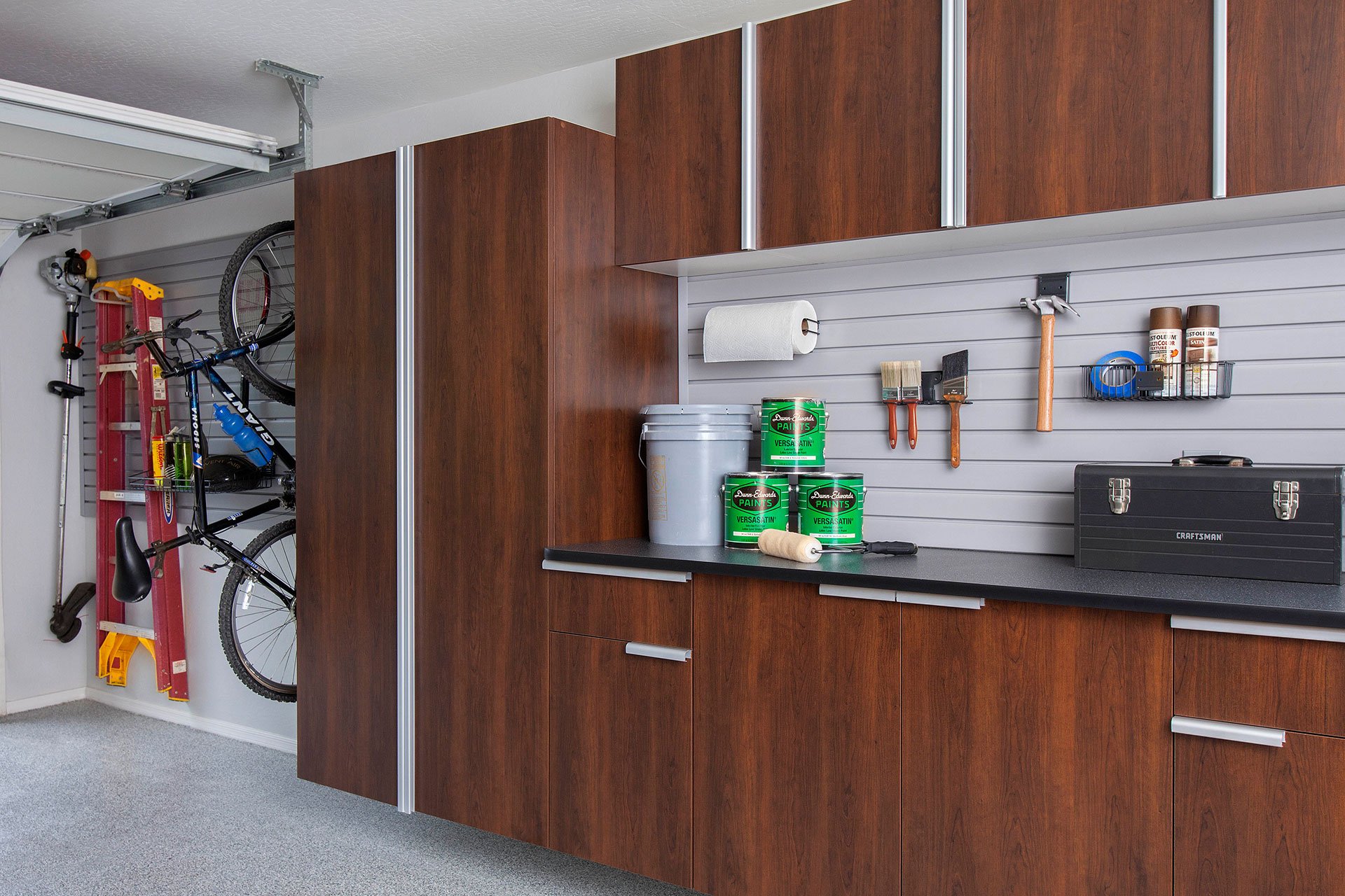 Organized garage with built in cabinets and other storage solutions. 