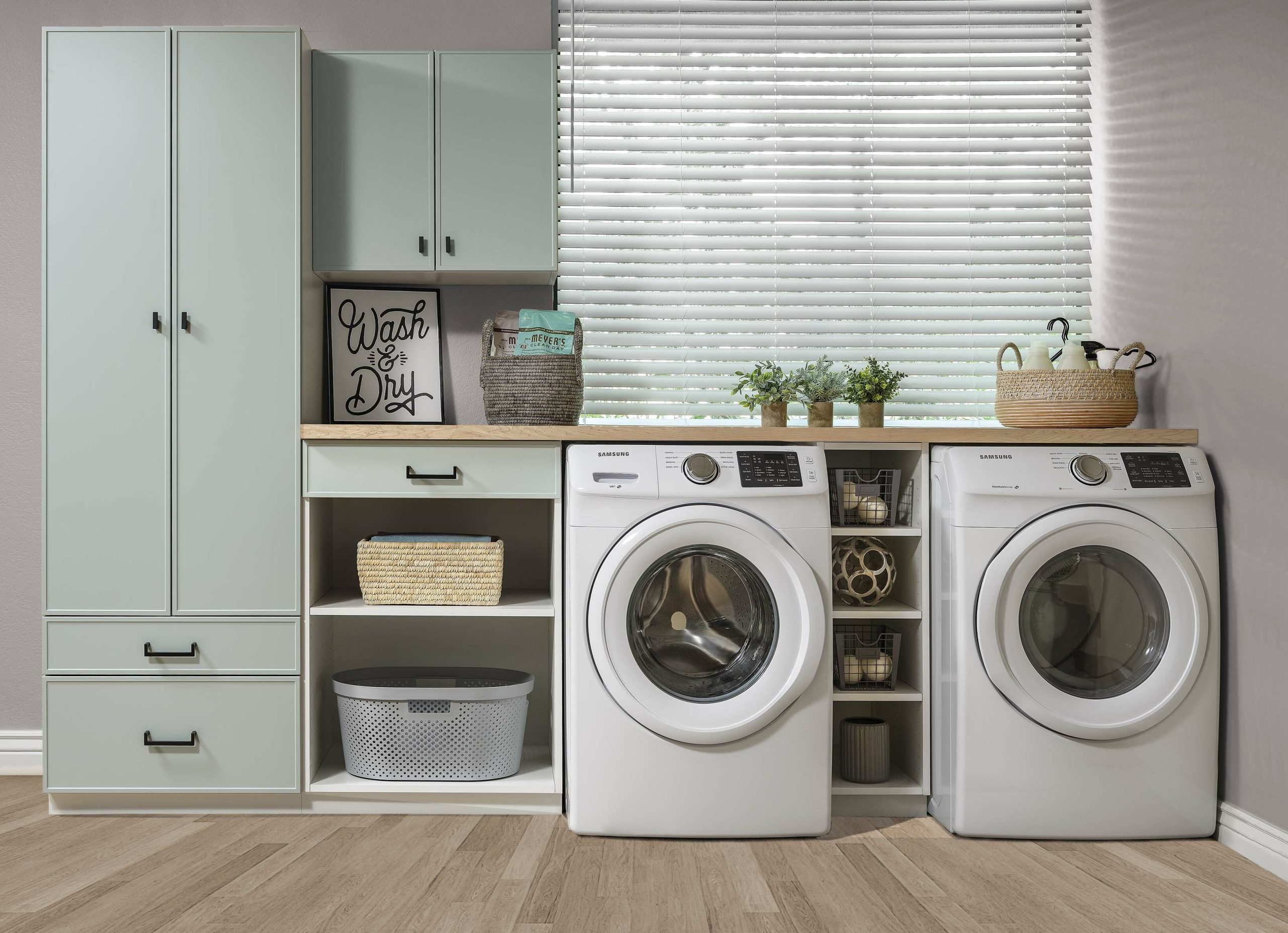 Organized laundry room with a custom storage including shelving and drawers. 