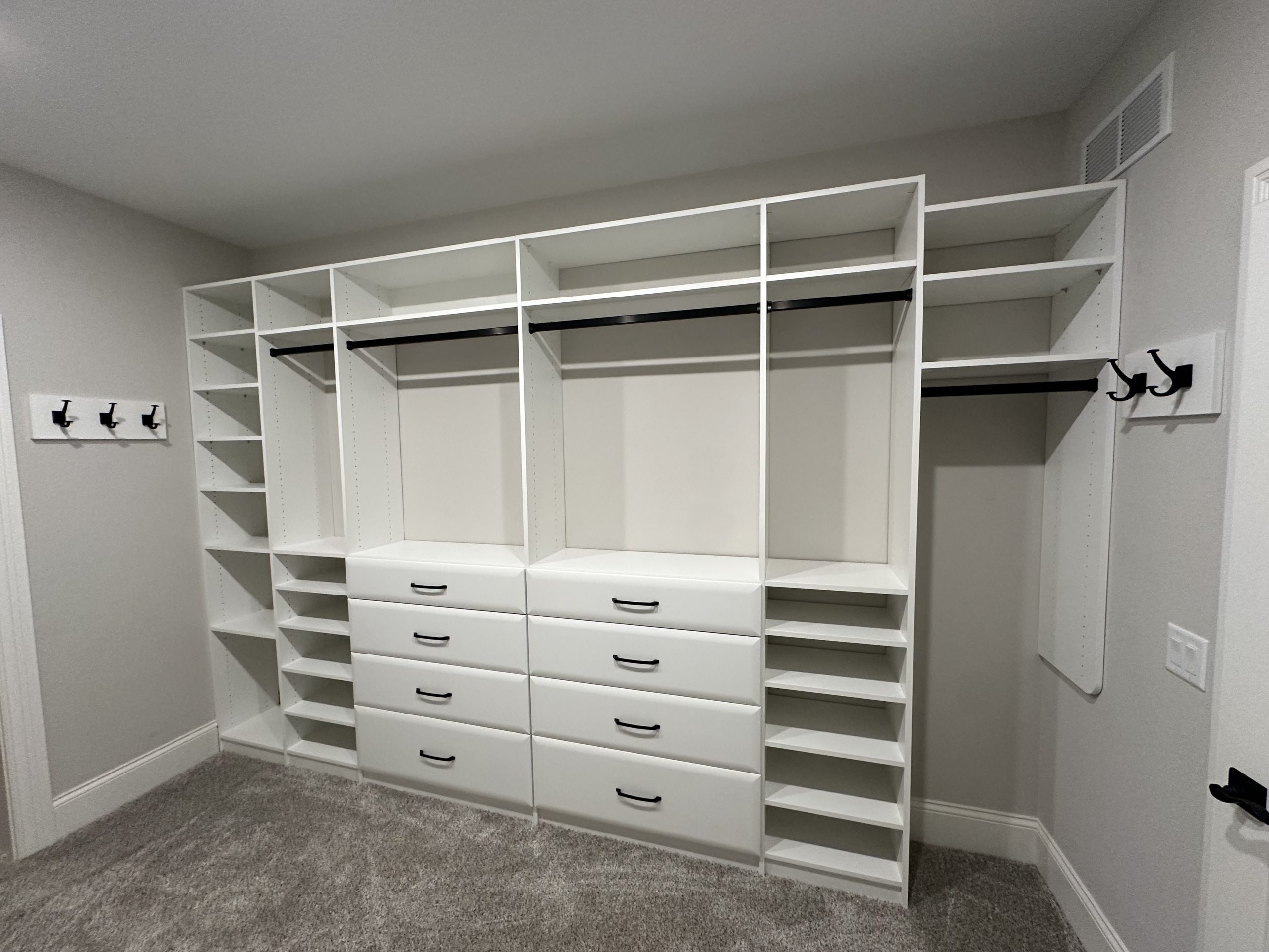 Custom closet with white built in shelves and drawers.