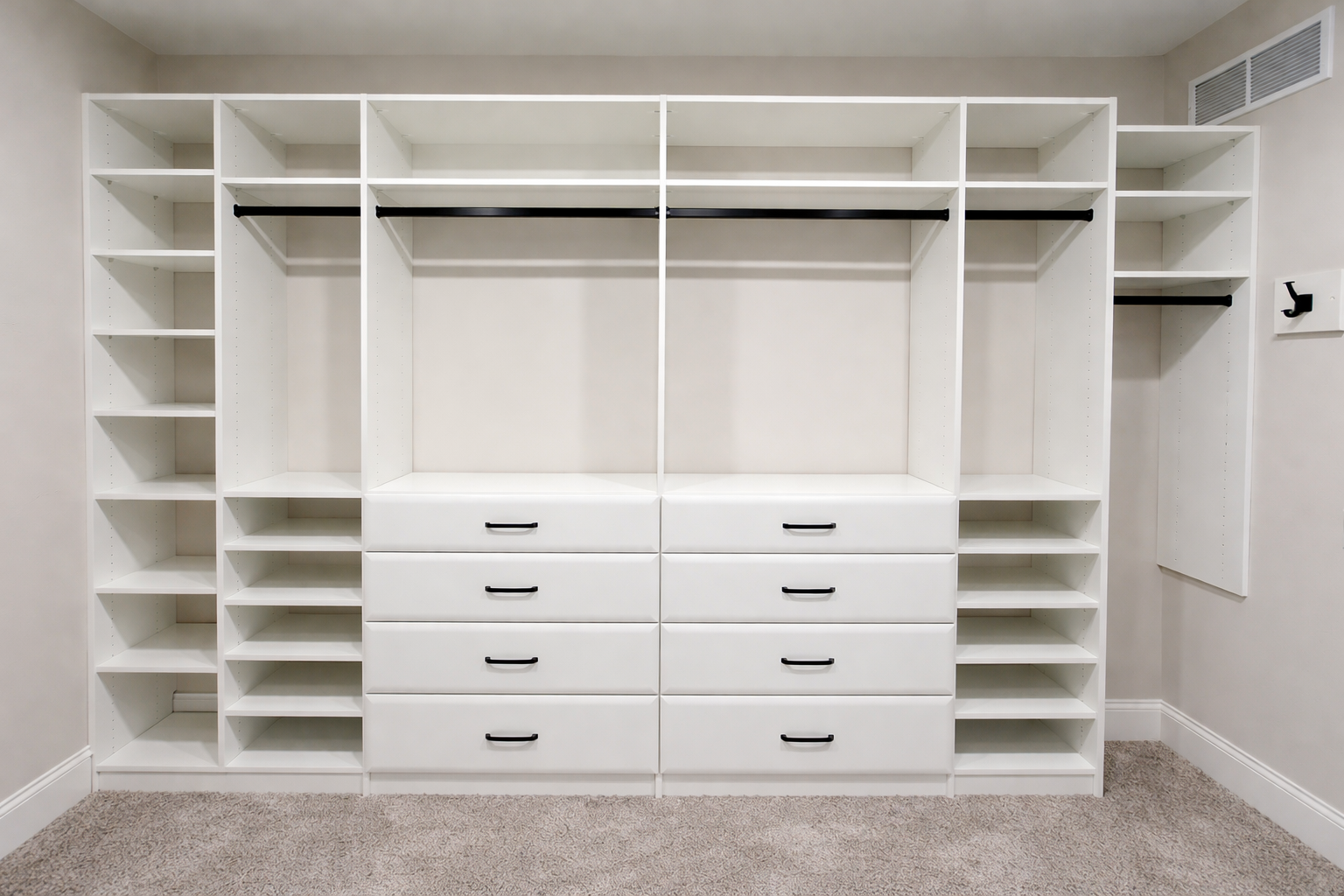 Custom built closet system with white shelves and drawers.